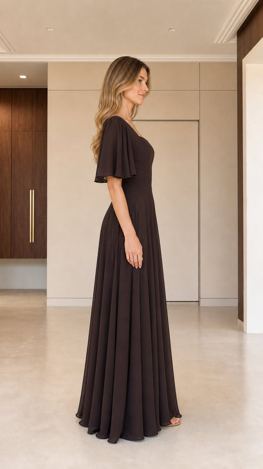 Side profile of woman in chocolate brown flutter sleeve A-line maxi dress