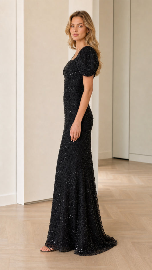 Side profile view of black floor-length sequin dress with puff sleeves